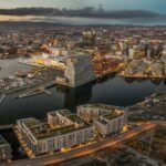 Aerial shot of Oslo at sunset, with lots of buildings and lights, surrounded by sea, Norway