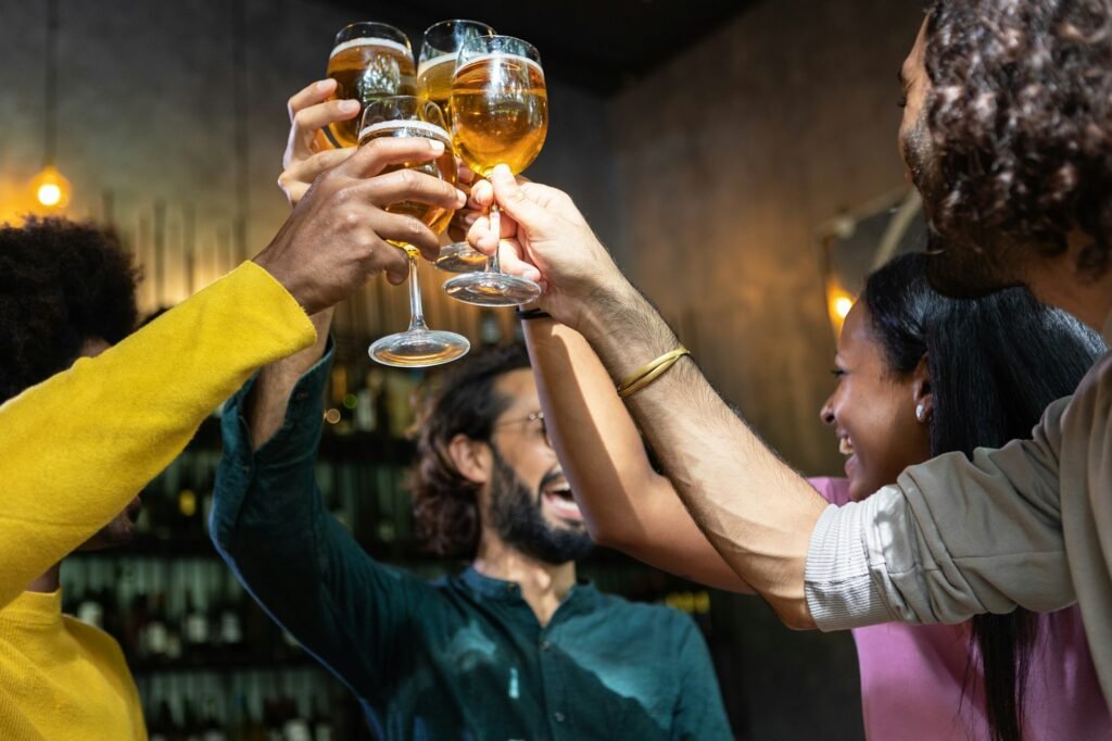 Young group of multiracial people toasting cold beer at happy hours brewery bar